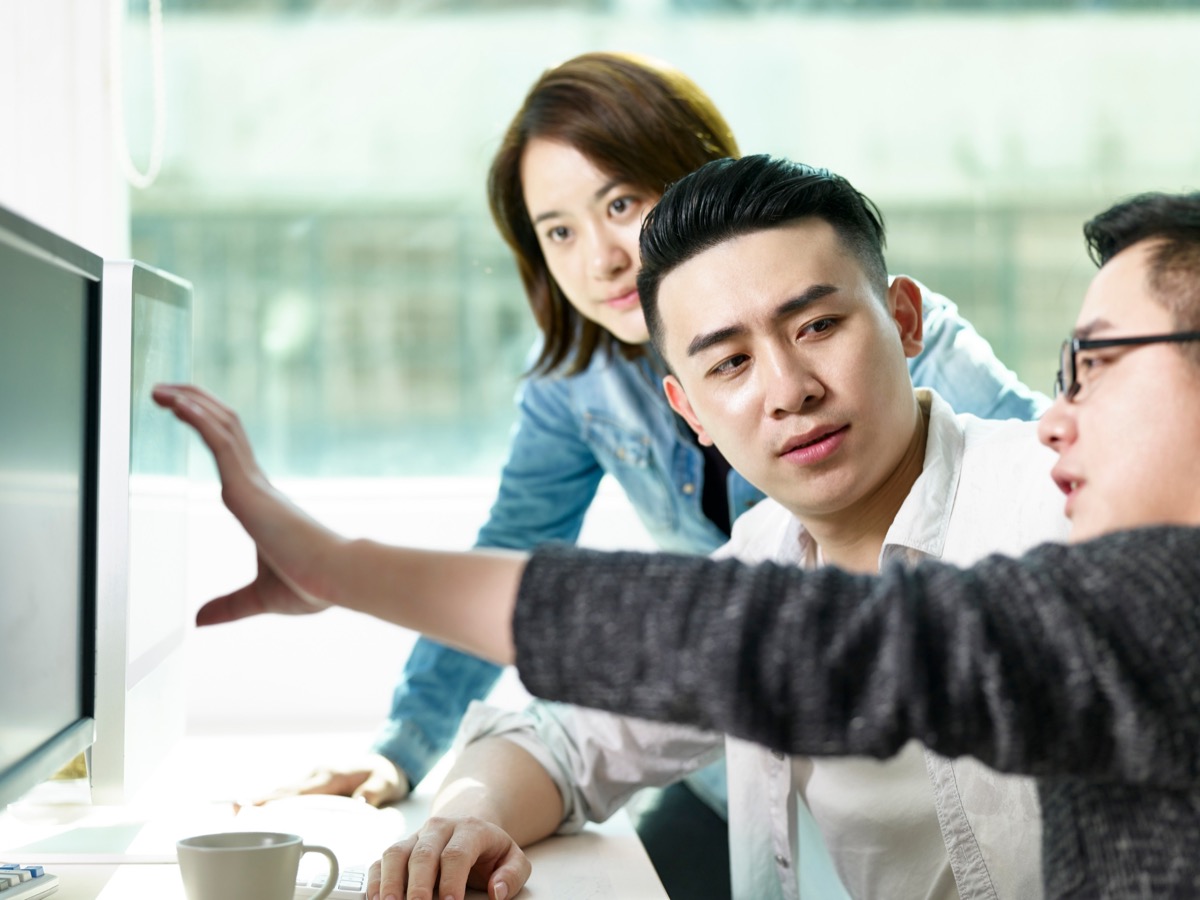 Group of professional talking in front of a computer; medical affairs data concept