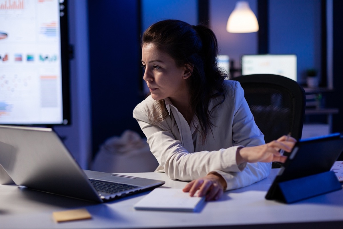 Female professional working on her laptop at her desk; automated eTMS tools concept