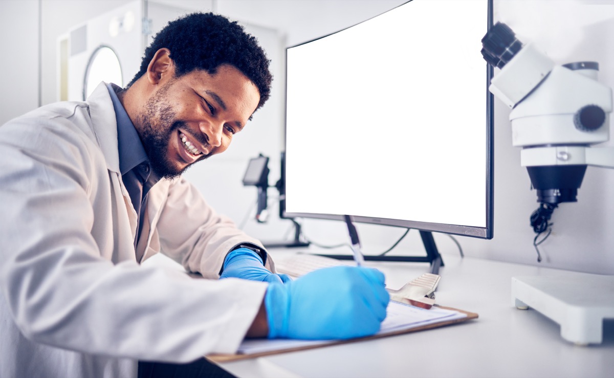 Medical professional in lab coat, writing on clipboard; data integration concept