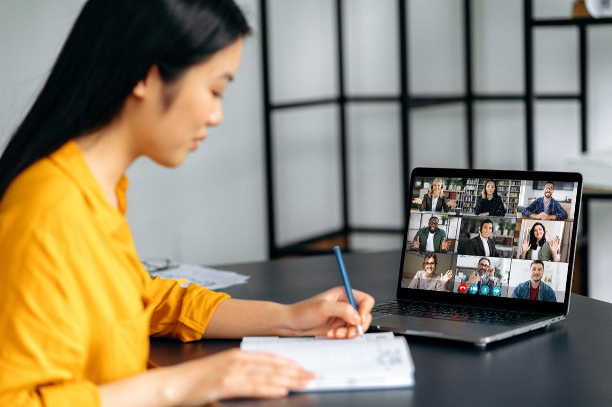 Woman taking notes during a video conference; opinion leader relationships concept 