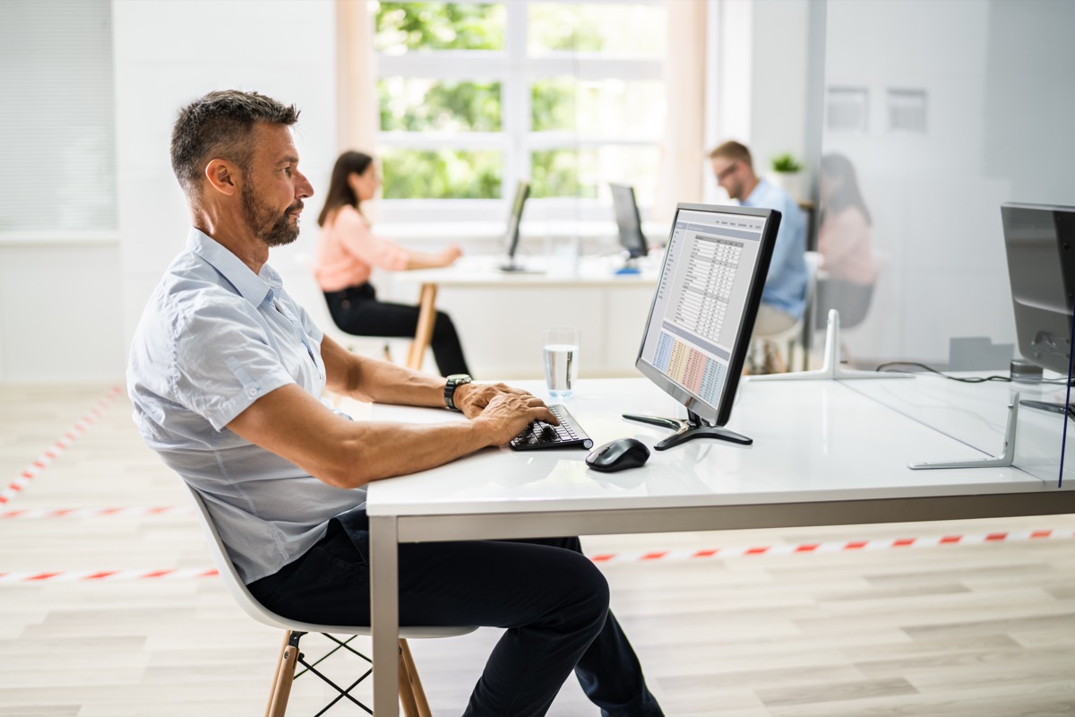 Man working on laptop; data silos concept