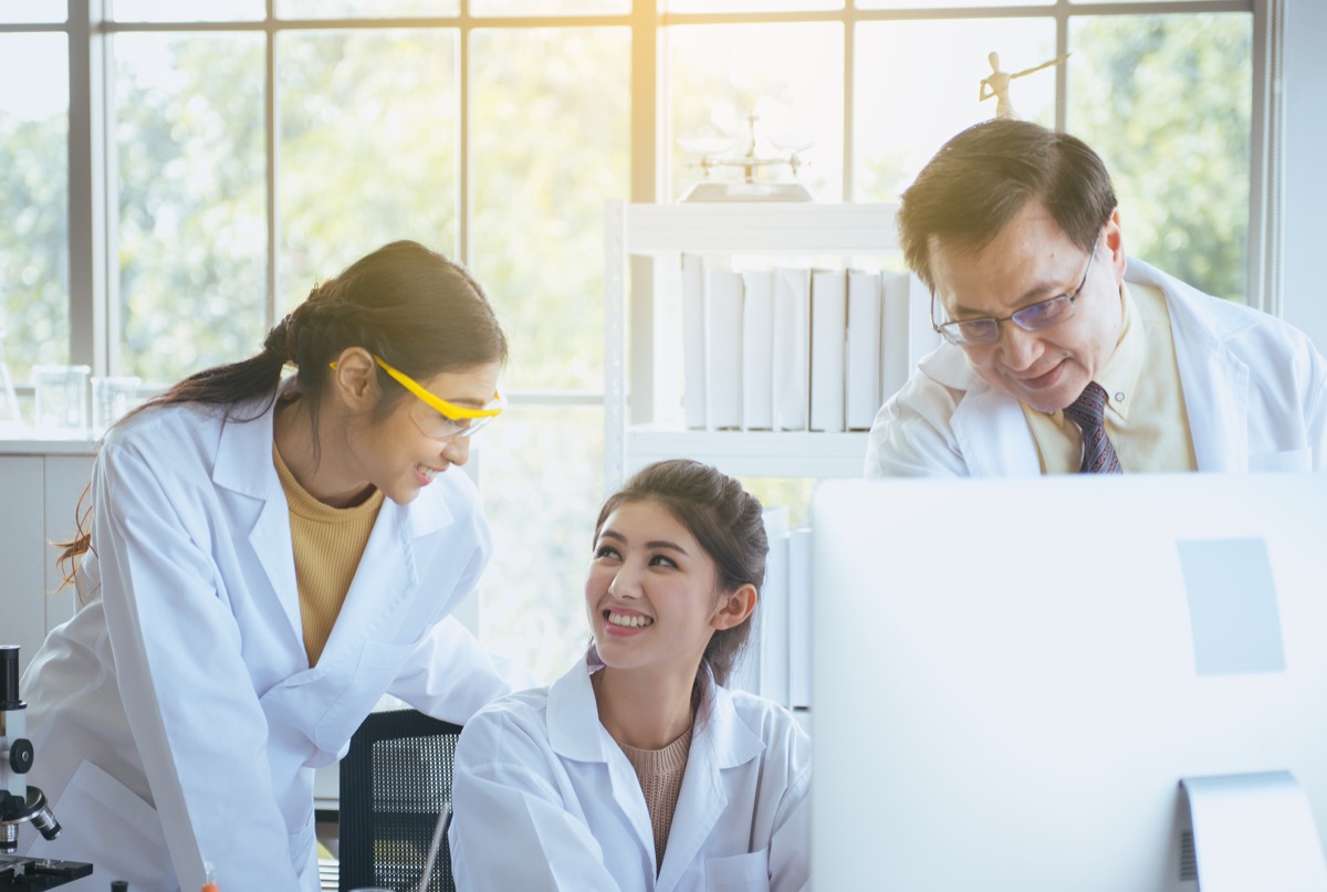 Group of medical technicians working and analyzing data research information together in the laboratory; data silos concept