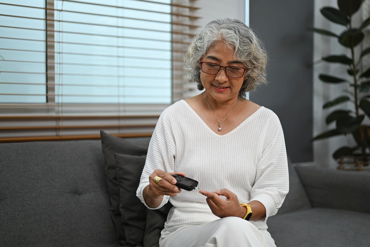 Women testing her blood with portable device; tech fatigue concept