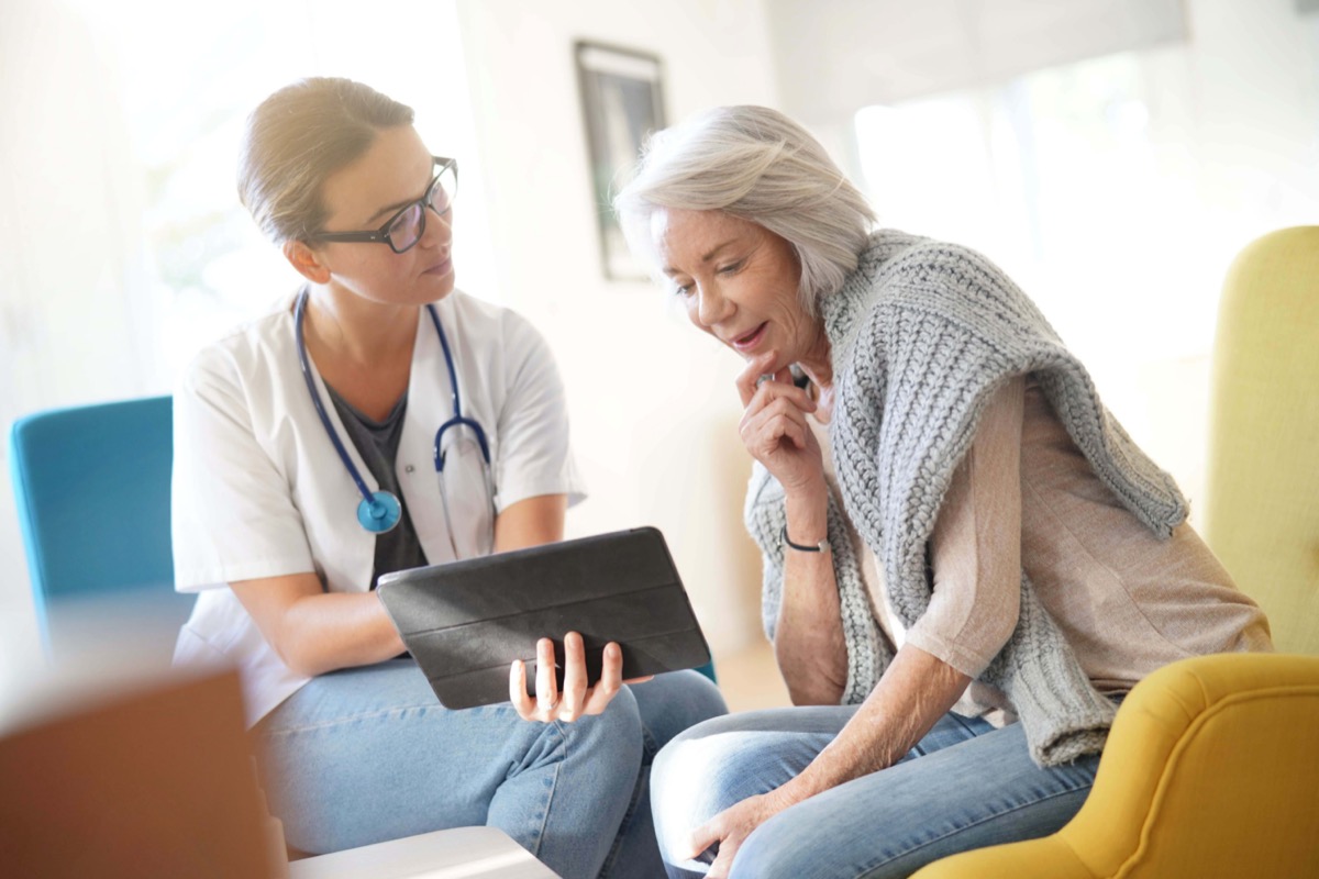 Doctor going through results and medication on tablet with senior patient; pharmaceutical innovation concept