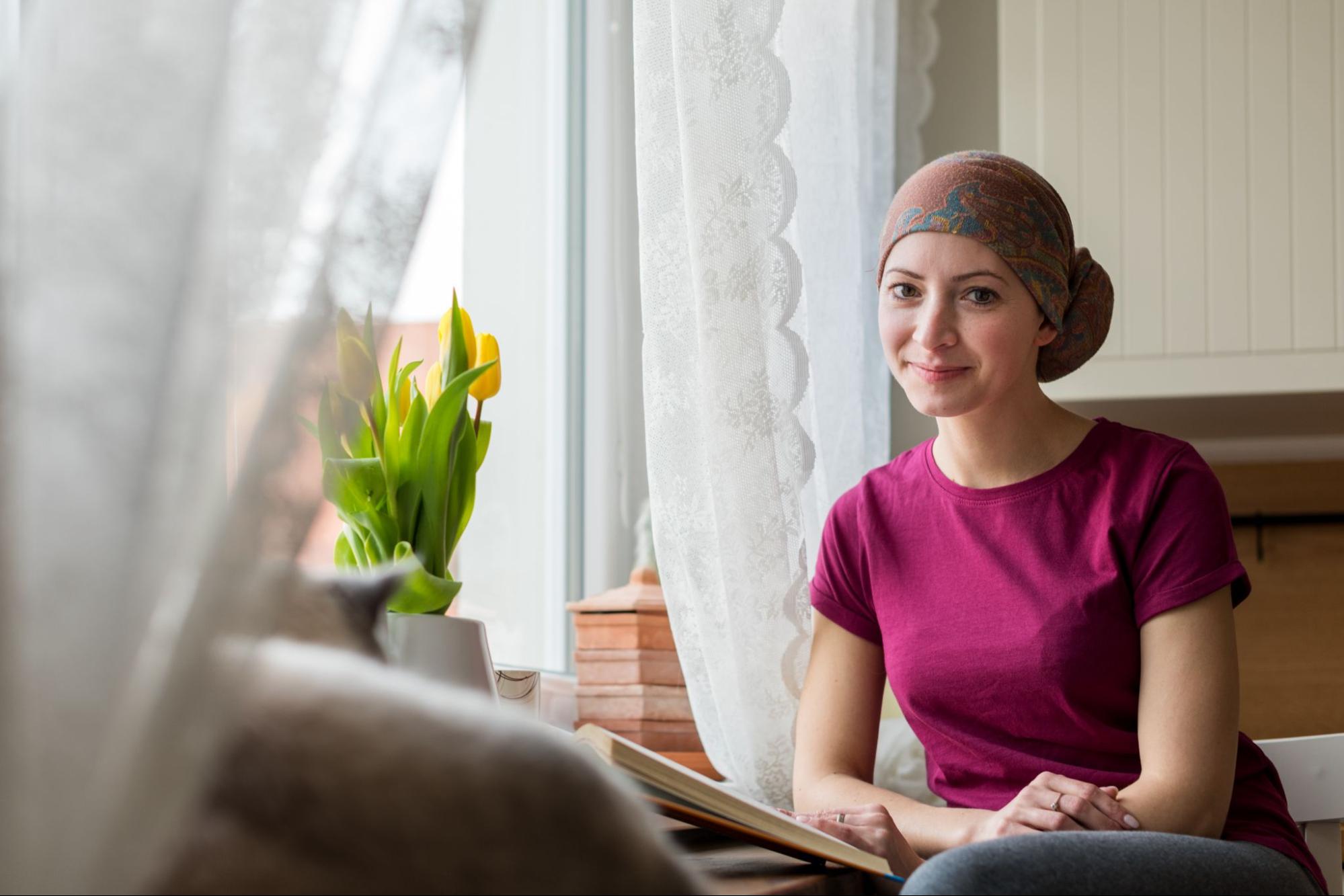 Seated woman wearing kerchief, reading; pharmaceutical innovation concept
