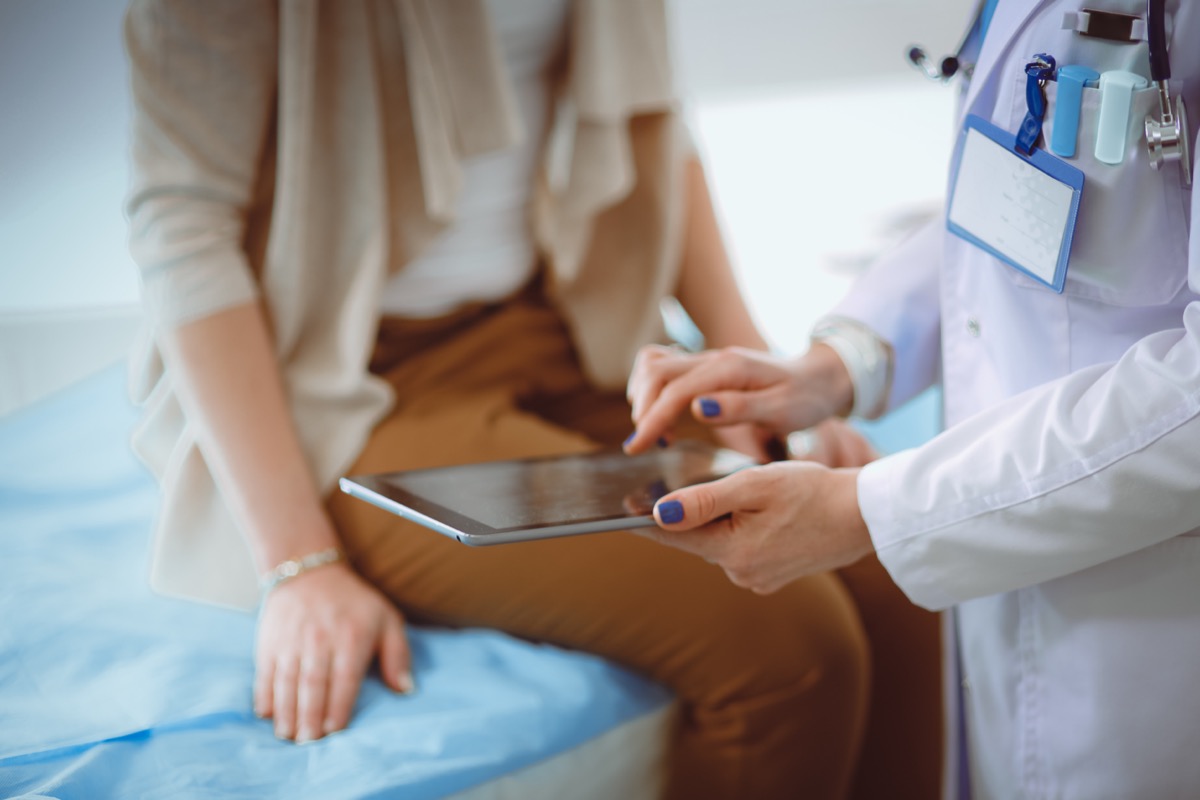 Doctor and patient discussing something using tablet; pharmaceutical innovation concept