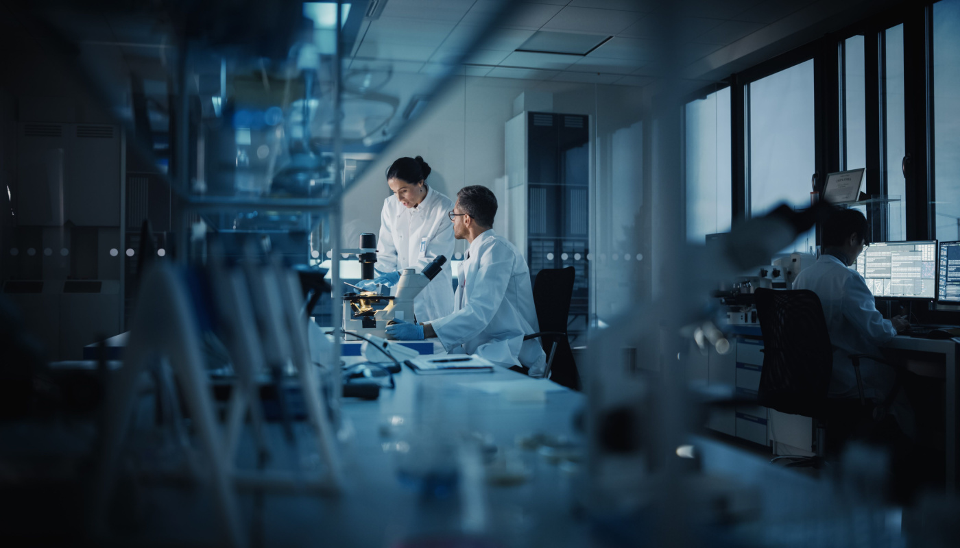 Techs working in darkened lab; umbrella trials concept