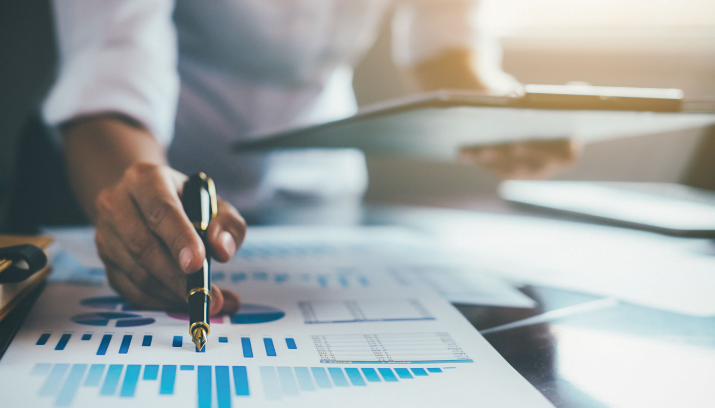 Person checking graph against information on clipboard; compliance auditing concept