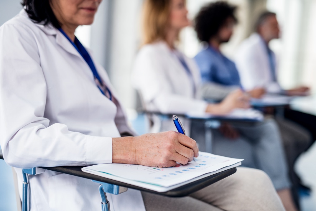 Group of healthcare professionals at a conference, listening and taking notes; SCOPE Europe 2023 concept