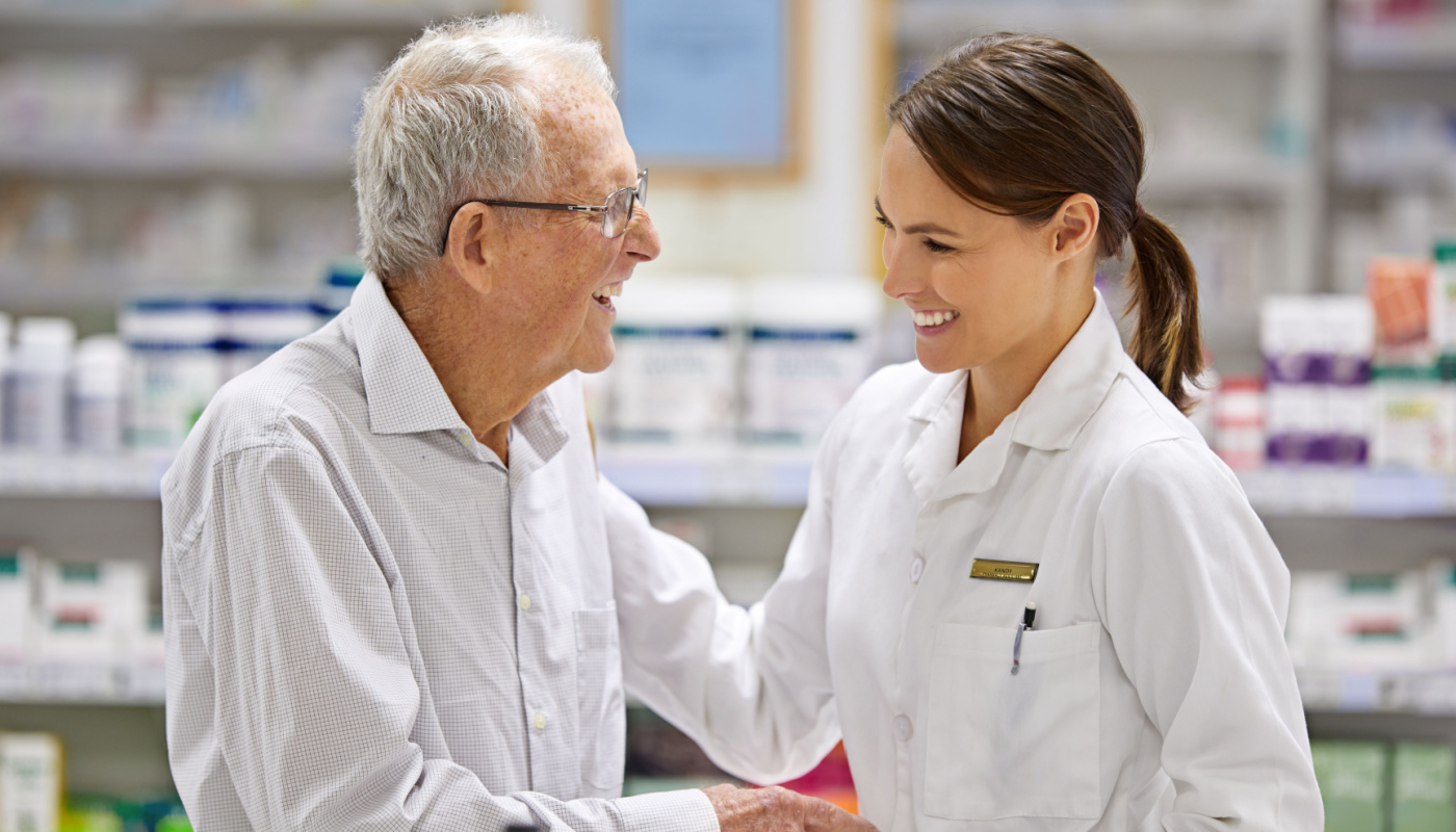 Pharmacist helping an elderly customer; predictive enrollment concept