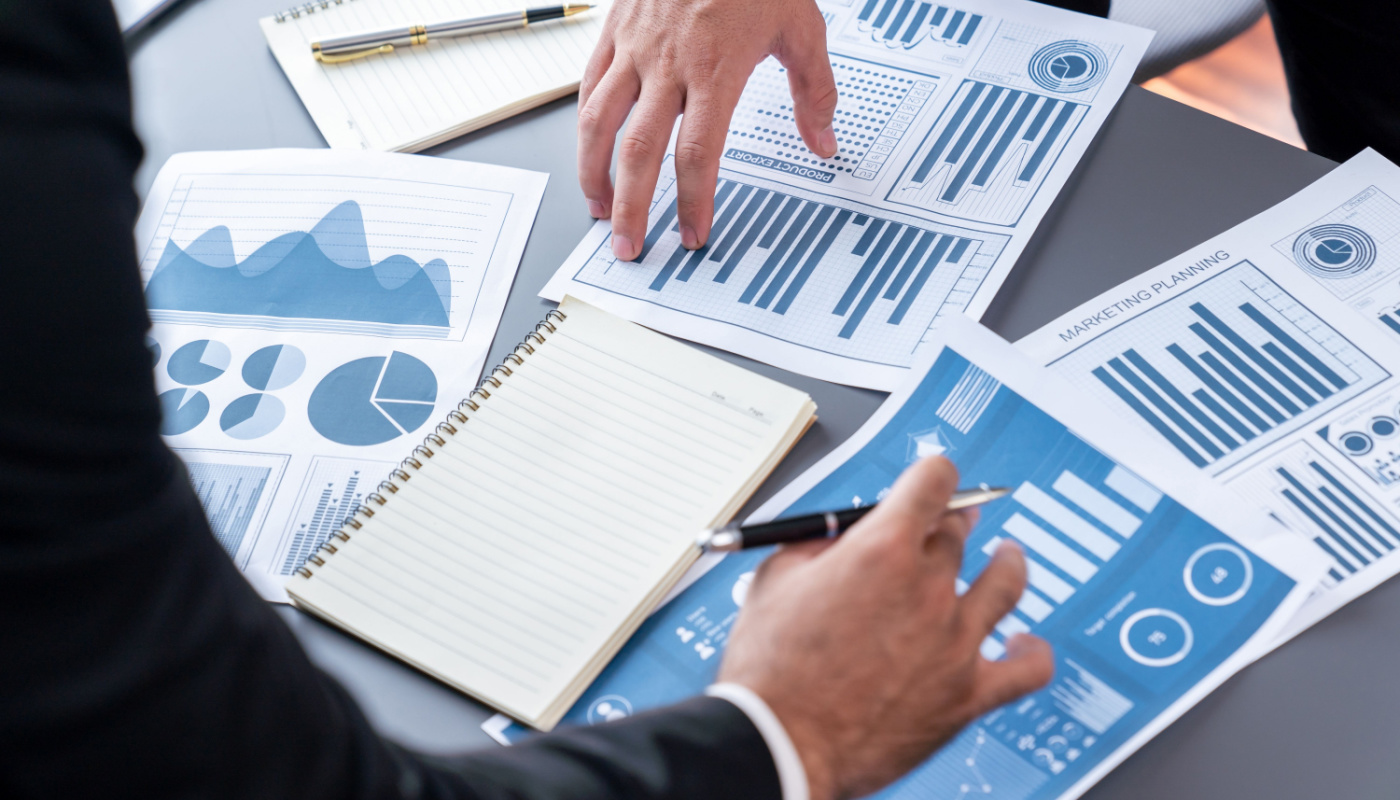 Closeup busy analyst team discussing financial data, analyzing charts and graphs; clinical trial costs concept