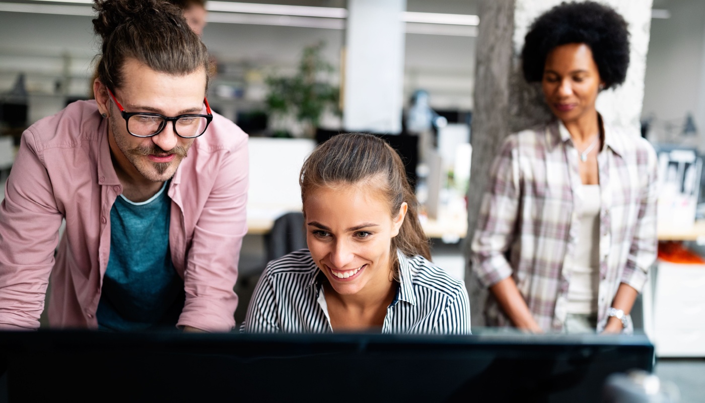 Young professionals working together at a computer; medical information management concept