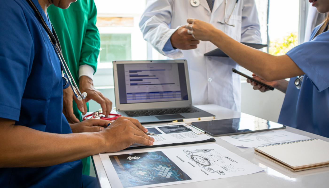 Medical team using lap top during meeting; generative AI medical affairs concept