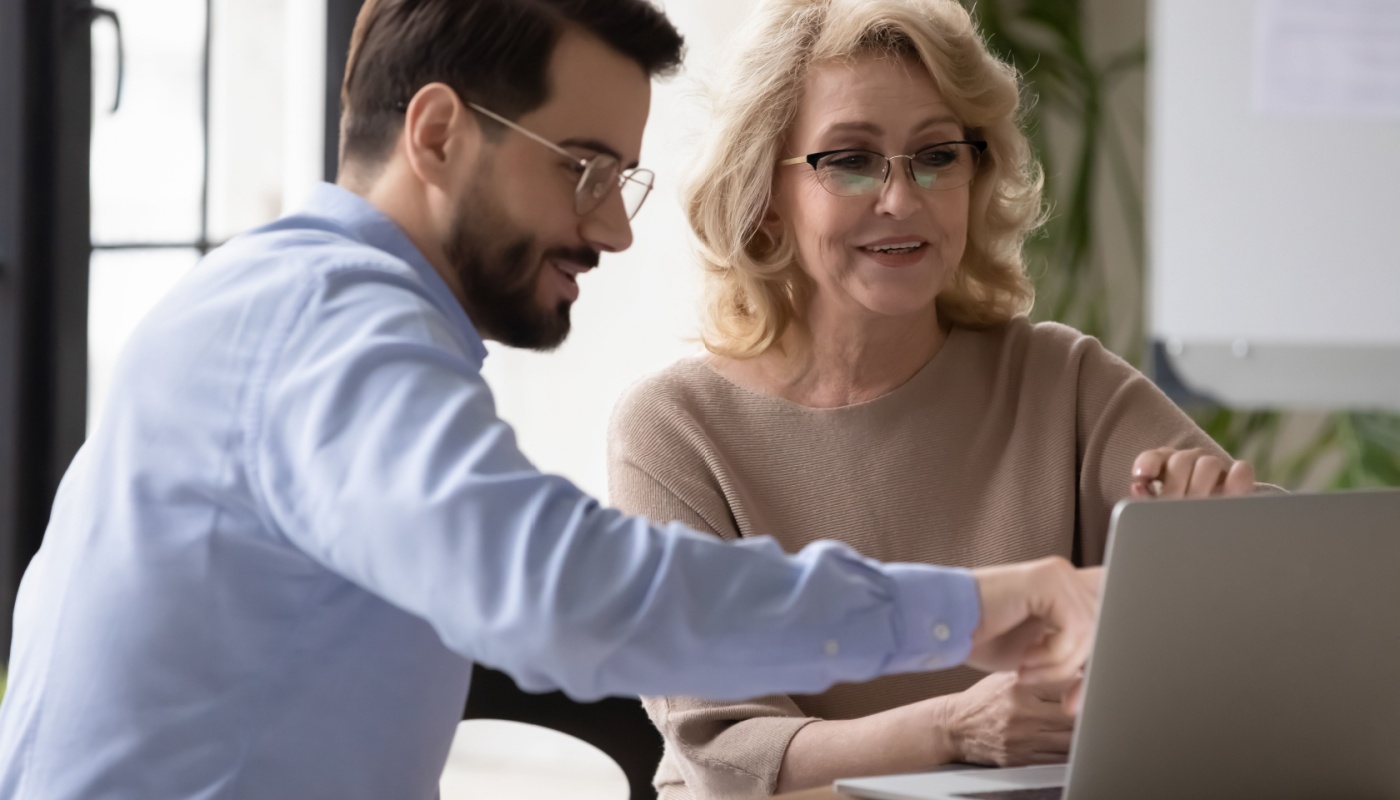 Colleagues look at laptop screen; MA decision-making concept