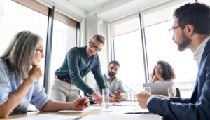 Businesspeople working together on research plan in boardroom; clinical trial financial management concept